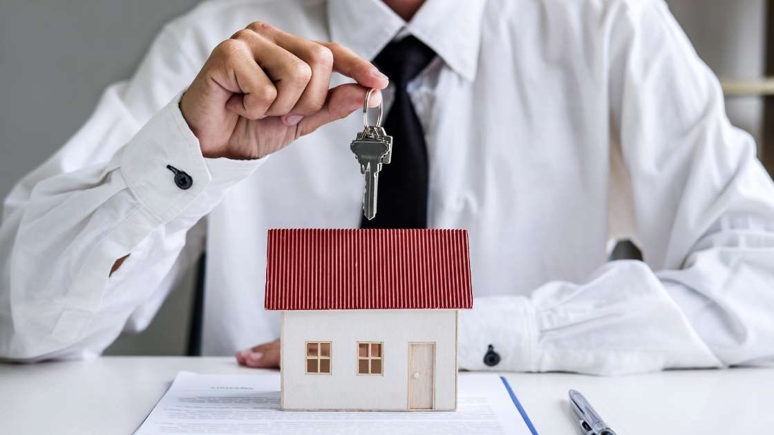 property manager holding a key over a miniature house